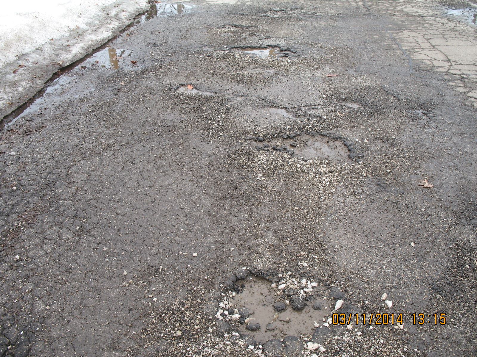 Potholes and Cracks in Asphalt of a Street